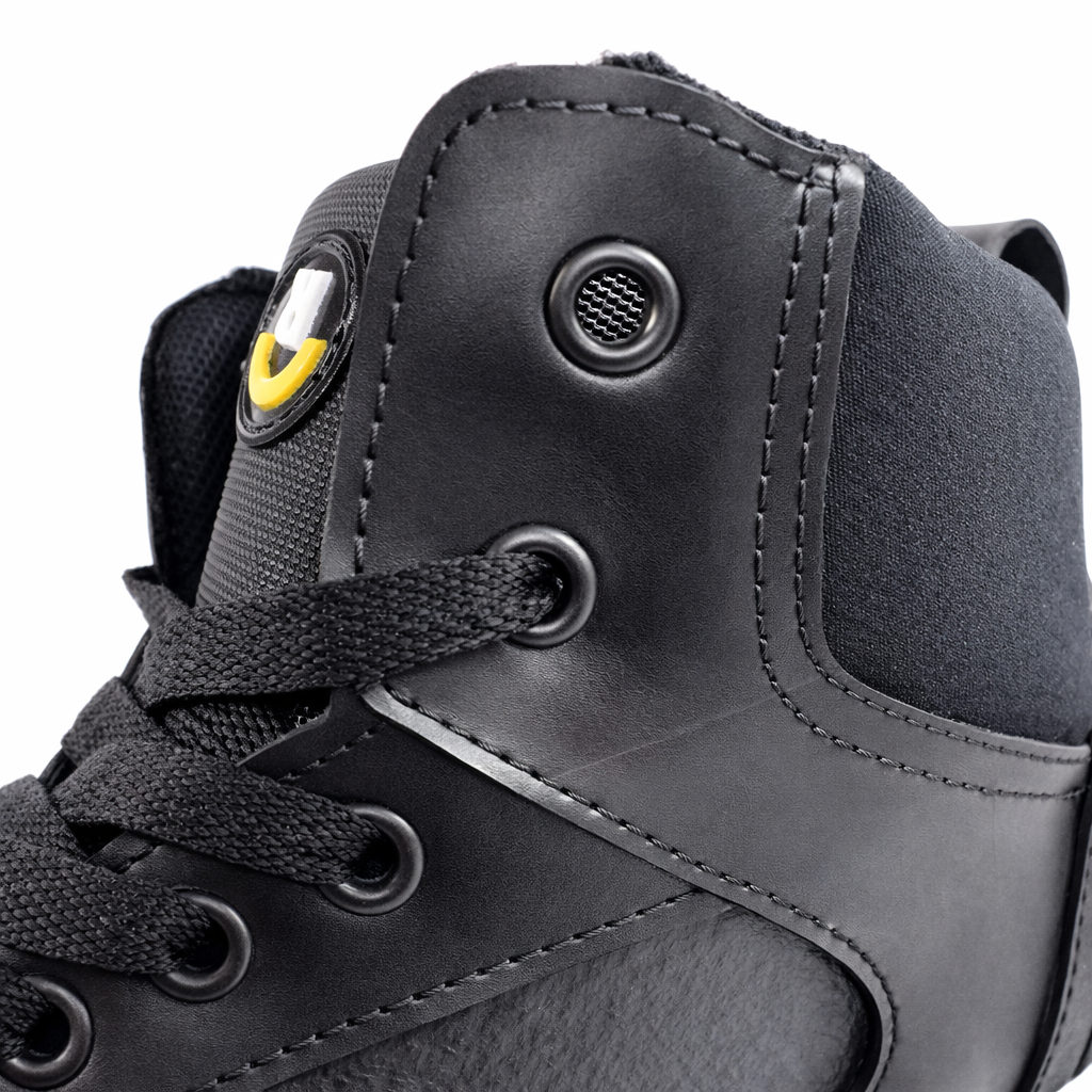 Detalle del sneaker Brea de Revolución Urbana con cordones negros, ojales y capellada en neumático reciclado.